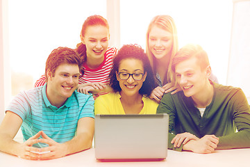 Image showing smiling students looking at laptop at school