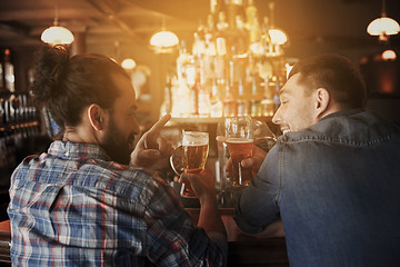 Image showing happy male friends drinking beer at bar or pub