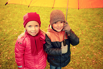 Image showing happy boy and girl with umbrella in autumn park