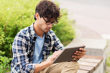 Image showing man with tablet pc sitting on city street bench