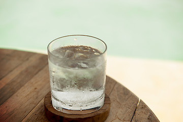 Image showing glass of water with ice cubes on table at beach