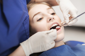 Image showing female dentist checking patient girl teeth