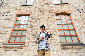 Image showing man with smartphone drinking coffee on city street