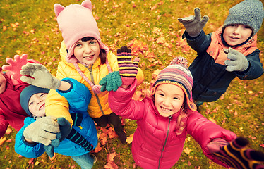 Image showing happy children waving hands in autumn park