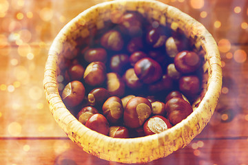 Image showing close up of chestnuts in basket on wooden table