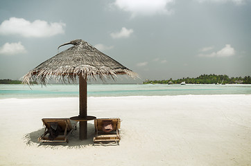 Image showing palapa and sunbeds by sea on maldives beach