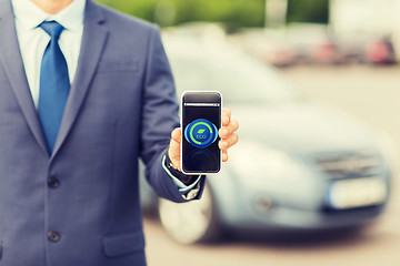 Image showing close up of business man with smartphone and car