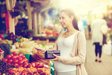 Image showing pregnant woman with wallet buying food at market