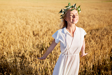 Image showing happy young woman in flower wreath on cereal field