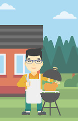 Image showing Man cooking chicken on barbecue grill.