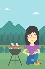 Image showing Woman cooking meat on barbecue.