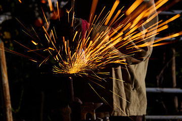 Image showing Worker cutting metal with grinder. Sparks while grinding iron