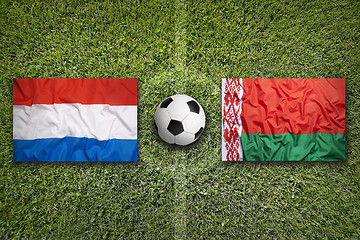 Image showing Netherlands and Belarus flags on soccer field