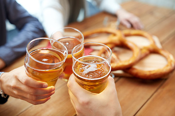 Image showing close up of hands clinking beer at bar or pub