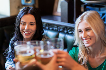 Image showing happy female friends drinking beer at bar or pub