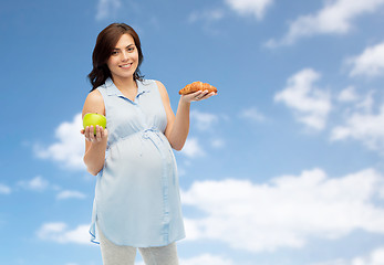 Image showing happy pregnant woman with apple and croissant