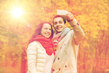 Image showing smiling couple hugging in autumn park