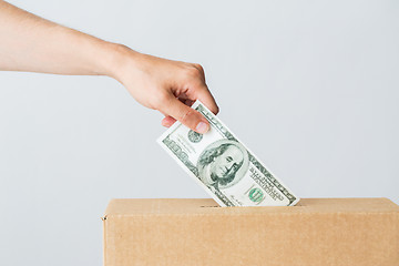 Image showing man putting dollar money into donation box