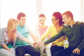 Image showing smiling students with hands on top of each other