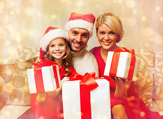 Image showing smiling family giving many gift boxes