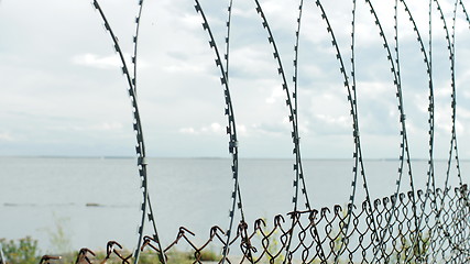 Image showing Sea behind barbed wire fences