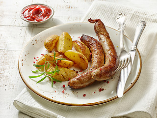 Image showing grilled sausages and potatoes on white wooden table