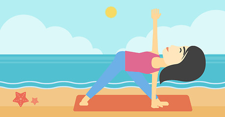 Image showing Woman practicing yoga triangle pose on the beach.