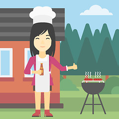 Image showing Woman cooking meat on gas barbecue grill.