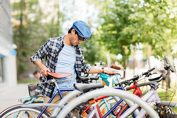 Image showing hipster man parking fixed gear bike on city street