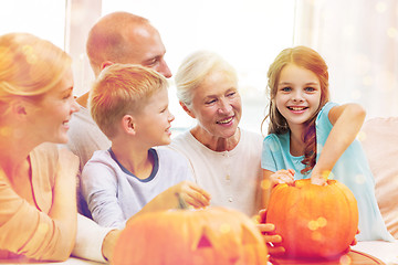 Image showing happy family sitting with pumpkins at home