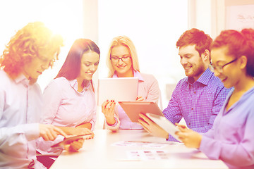 Image showing smiling team with table pc and papers working