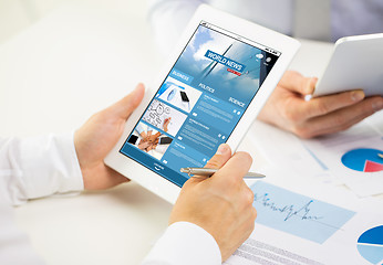 Image showing close up of hands with business news on tablet pc