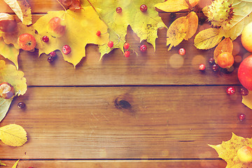 Image showing frame of autumn leaves, fruits and berries on wood