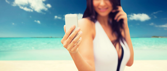 Image showing young woman taking selfie with smartphone on beach