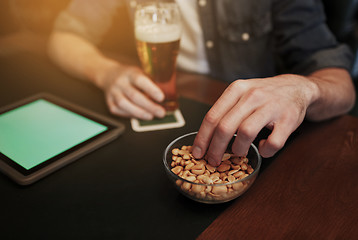 Image showing man with tablet pc, beer and peanuts at bar or pub