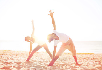 Image showing couple making yoga exercises outdoors