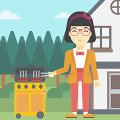 Image showing Woman cooking meat on gas barbecue grill.