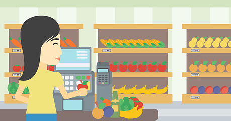 Image showing Cashier standing at the checkout in supermarket.