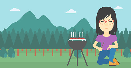 Image showing Woman cooking meat on barbecue.