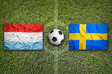 Image showing Luxembourg and Sweden flags on soccer field