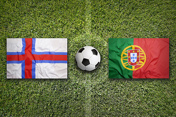 Image showing Faroe islands vs. Portugal flags on soccer field