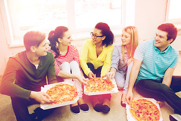 Image showing five smiling teenagers eating pizza at home