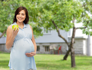 Image showing happy pregnant woman holding green apple