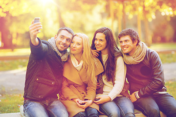 Image showing group of friends with photo camera in autumn park