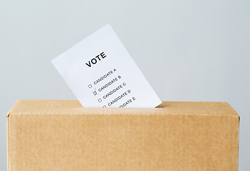 Image showing vote inserted into ballot box slot on election