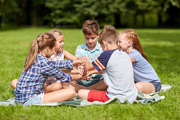 Image showing group of happy kids putting hands together