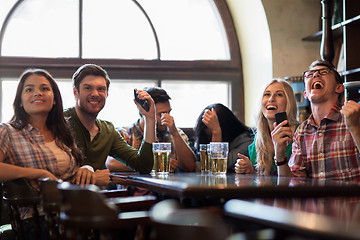 Image showing friends with beer watching football at bar or pub