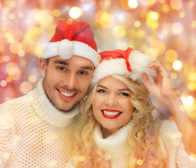 Image showing happy family couple in sweaters and santa hats