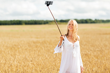 Image showing happy young woman taking selfie by smartphone