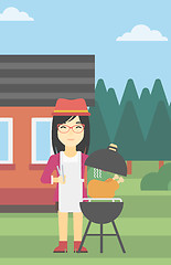 Image showing Woman cooking chicken on barbecue grill.